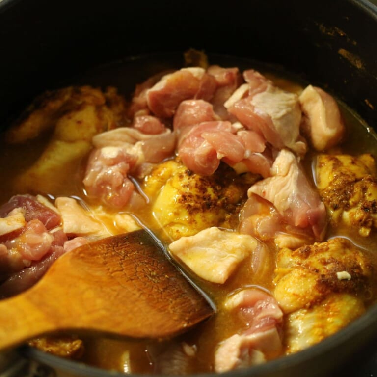 手順 3: 加えた鶏もも肉の色が変わったら、全ての水を加え、グツグツしてきたら弱火にして鶏もも肉に火がしっかり入るまで煮込む。（約3