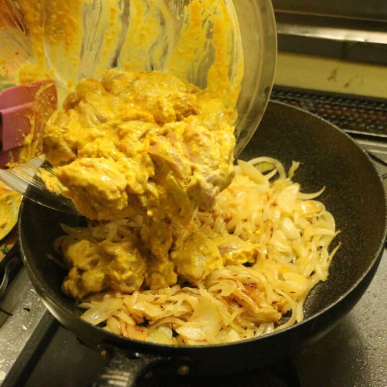 手順 5: 玉ねぎが透明になってきたら鶏もも肉をマリネ液ごと加え鶏もも肉の表面に火が通るまで炒める。
