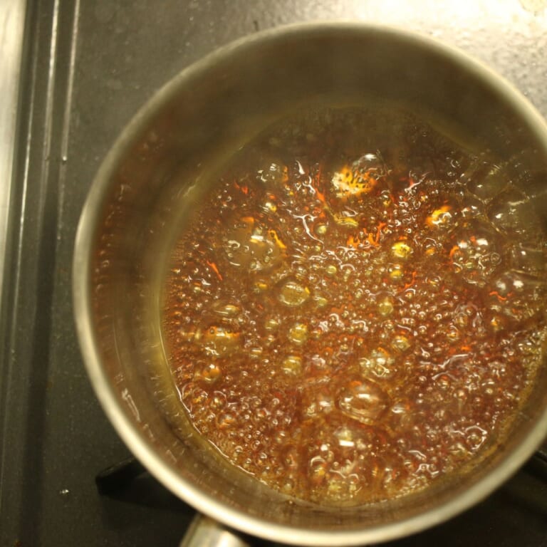 手順 2: カラメルを作るため、鍋に水を加え砂糖を入れて茶色くなるまで煮詰める。