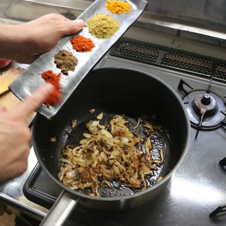 手順 3: スパイスBと塩を加え炒め合わせ鶏もも肉を加える。