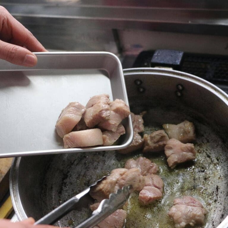 手順 2: 温めたフライパンに油をいれ、豚肉を炒め表面に火が入ってきたらとりだしておく。