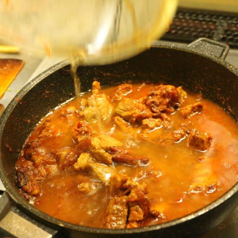 手順 6: 水を加えよく混ぜ、20分もしくは豚肉が柔らかくなるまで煮込む。(グツグツしてきたら弱火にする) 必要であれば塩で味を整え
