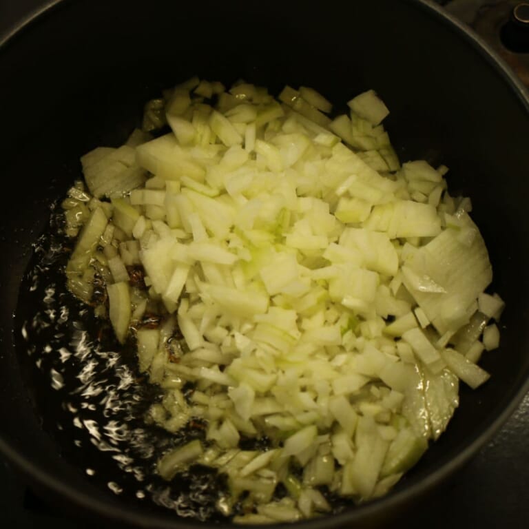 手順 1: 温めたフライパンに油とスパイスAを加え、シュワシュワしてきたら玉ねぎを入れる。