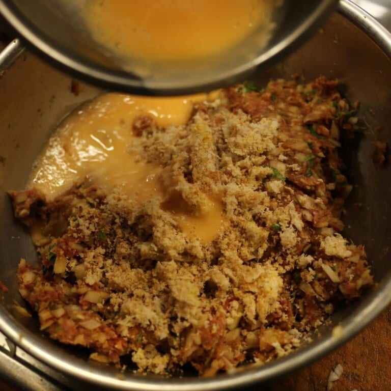 手順 1: パン粉と玉子以外の材料をボウルでよくこねたあと、パン粉と玉子(少しずつ)加え、さらにこねる。