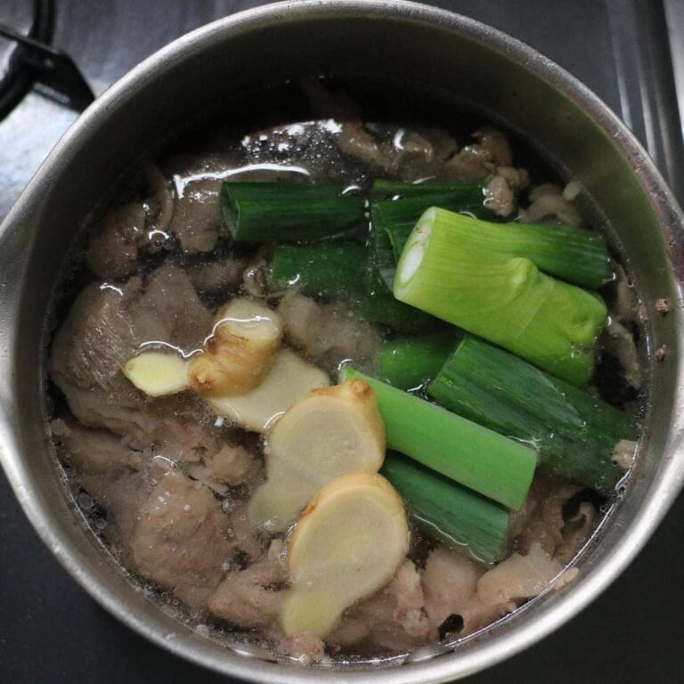 手順 2: ネギと生姜を加えて約60分くらい煮込む。 ゆで汁は後ほど使うので取っておく。 茹でたあとに水を入れ替える下処理を3回繰り