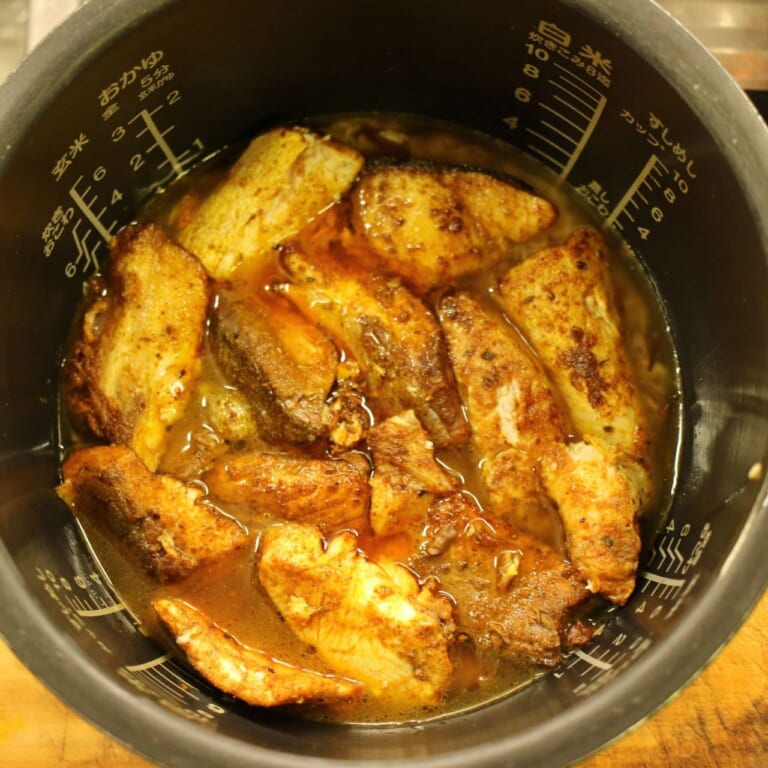 手順 5: フライパンの中身を全て炊飯器にいれ、水2カップ、取り出しておいた魚、スパイスミックスA、スパイスミックスBを加え炊飯器の