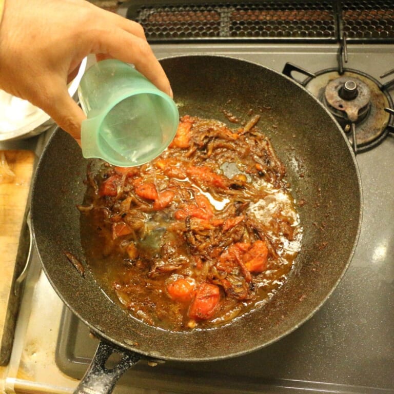 手順 5: トマトの形がなくなったら水を徐々に入れて、ソースのようになるまで火を入れます。