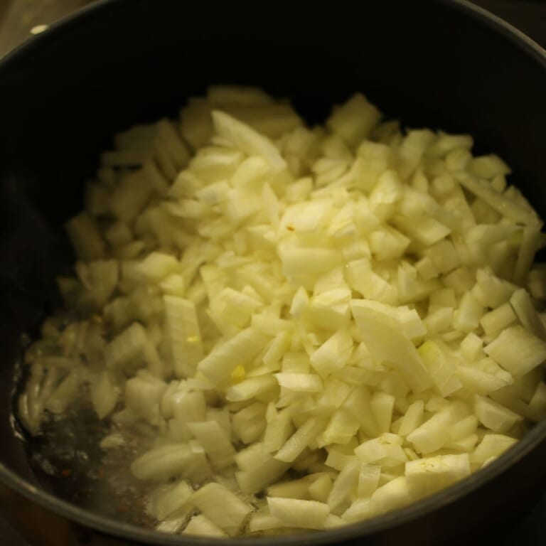 手順 2: 玉ねぎを加え薄い飴色になったらにんにく、生姜、カレーリーフを加え炒める。