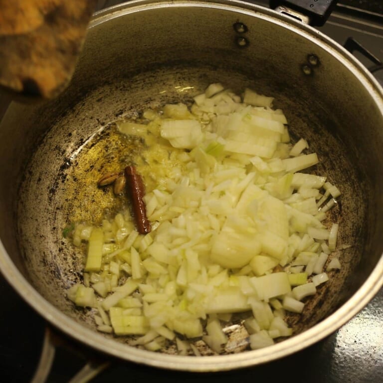 手順 3: 温めたフライパンに油とスパイスAを加え、スパイスの香りがたってきたら玉ねぎを加える。