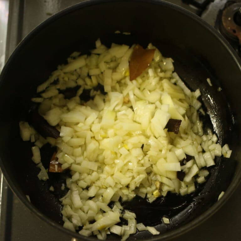 手順 2: 温めたフライパンに油とスパイスAを加える。カルダモンが膨らんできたら玉ねぎを加え薄い飴色になるまで炒める。