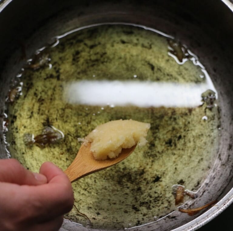 手順 3: 玉ねぎを取り除いた油に、にんにく、しょうがを加えます。