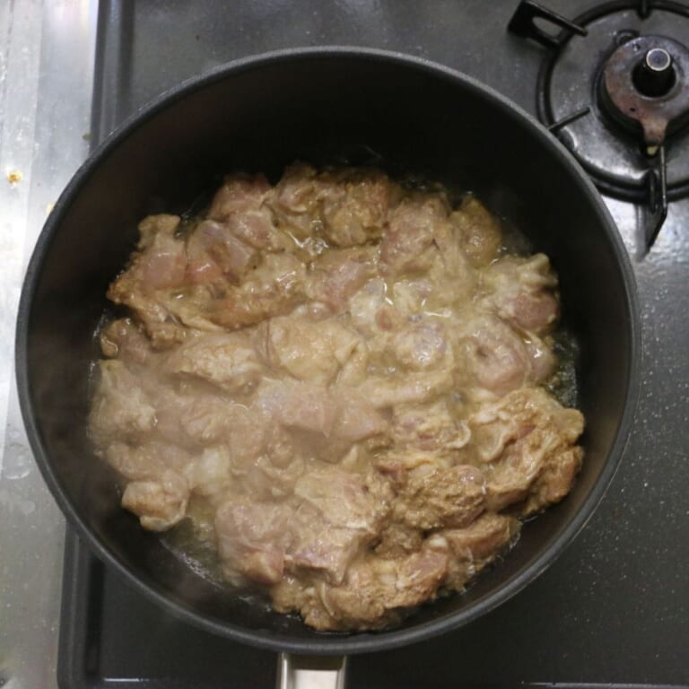 手順 2: フライパンに油をひき、つけておいた鶏もも肉を焼く。