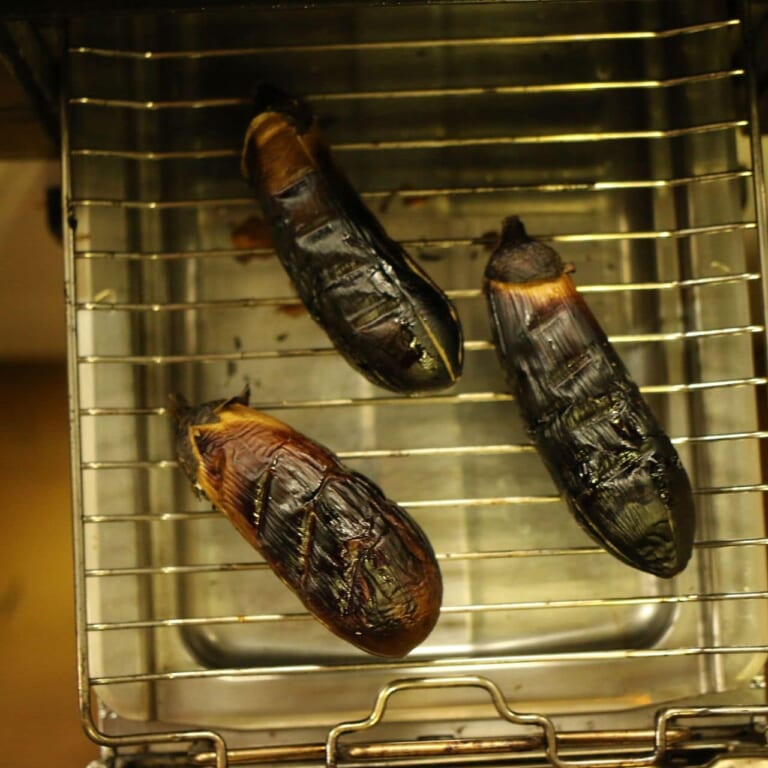 手順 1: ナスを直火で焼き、皮が黒くなってきたら冷まして皮をむきヘタをとっておく。