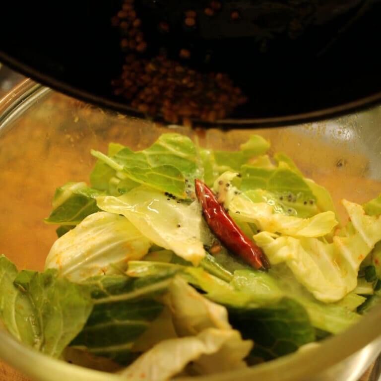 手順 3: パチパチして香りが立ってきたら油ごとキャベツに加える。