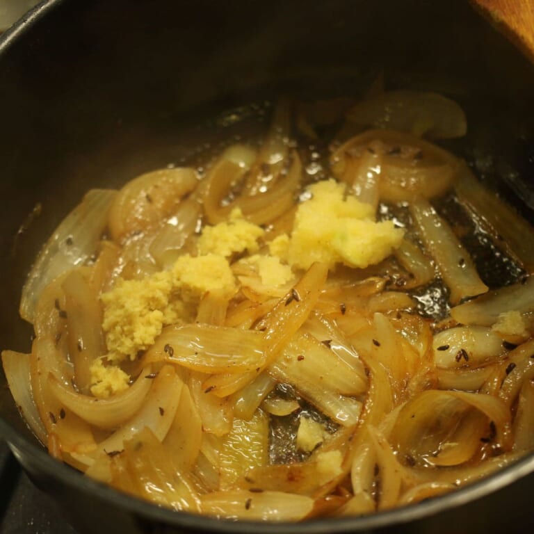 手順 4: 玉ねぎが飴色になったらにんにく、生姜を加える。