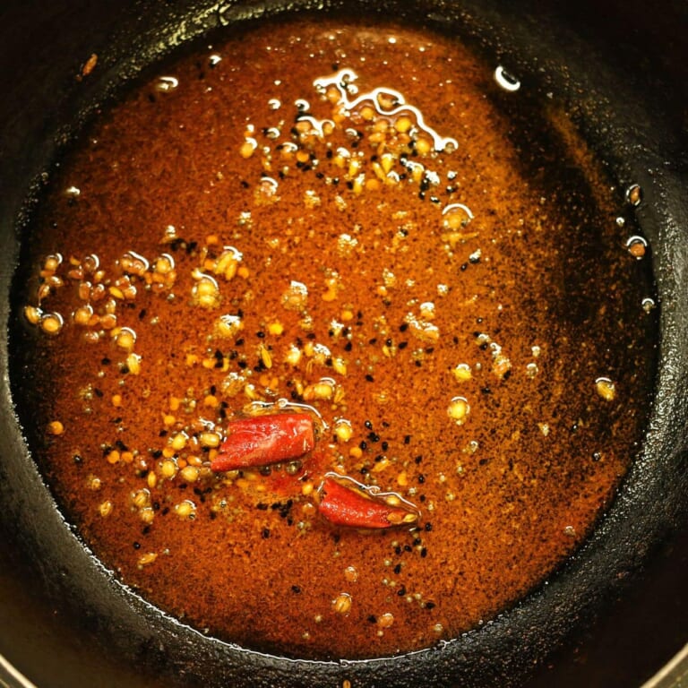 手順 5: パチパチとしてきたら火を止めスパイスBを加え混ぜ合わせ油ごと焼きなすに加える。
