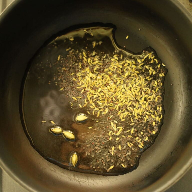 手順 1: 温めたフライパンに油を入れスパイスAを加え、香りが立ってきたら玉ねぎを加えて炒める。