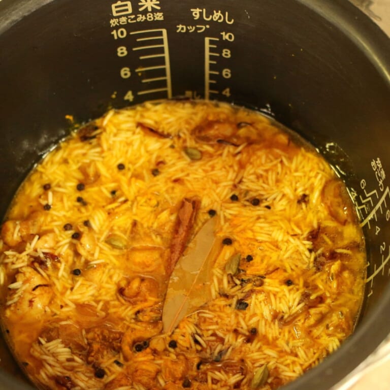 手順 5: フライパンの中身を全て炊飯器にいれ水2カップ、スパイスミックスA、スパイスミックスBを加え炊飯器のスイッチを入れる。