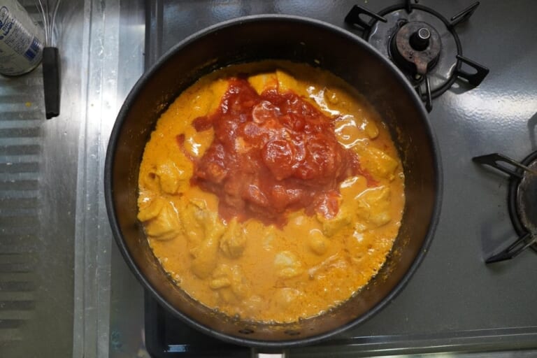 手順 4: 鶏肉に火が通り始めたら、トマト缶を加えて15分ぐらい煮込む。 ※アーモンドが焦げやすいので火加減に注意。