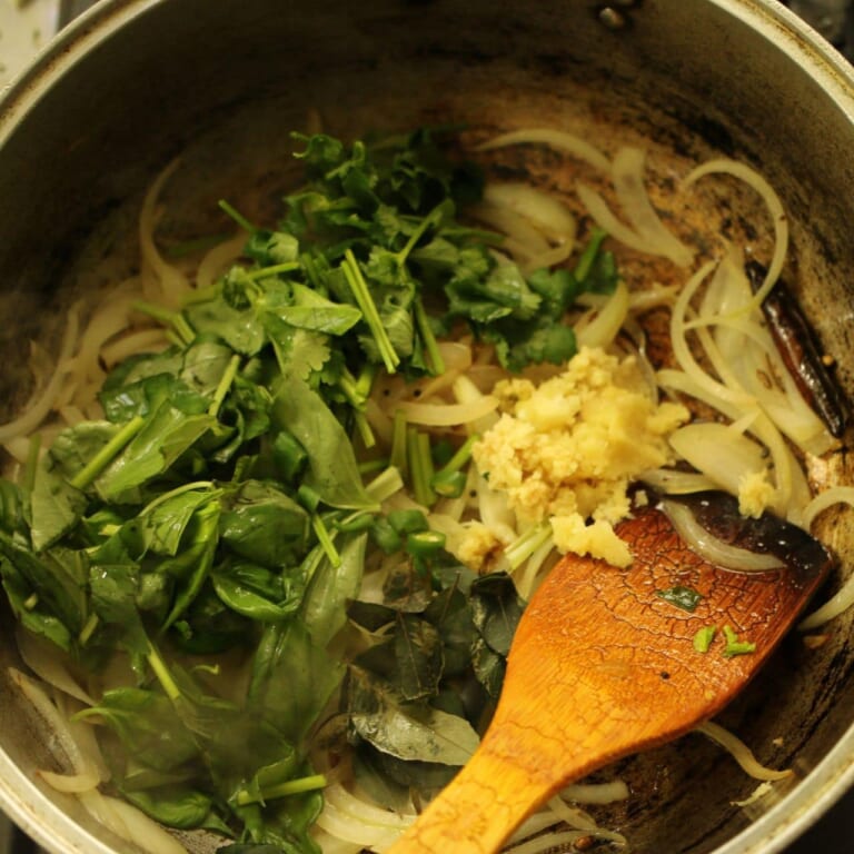 手順 3: 少し炒めたら、にんにく、生姜、青唐辛子、パクチー、バジル、カレーリーフ、塩を加え炒め合わせる。