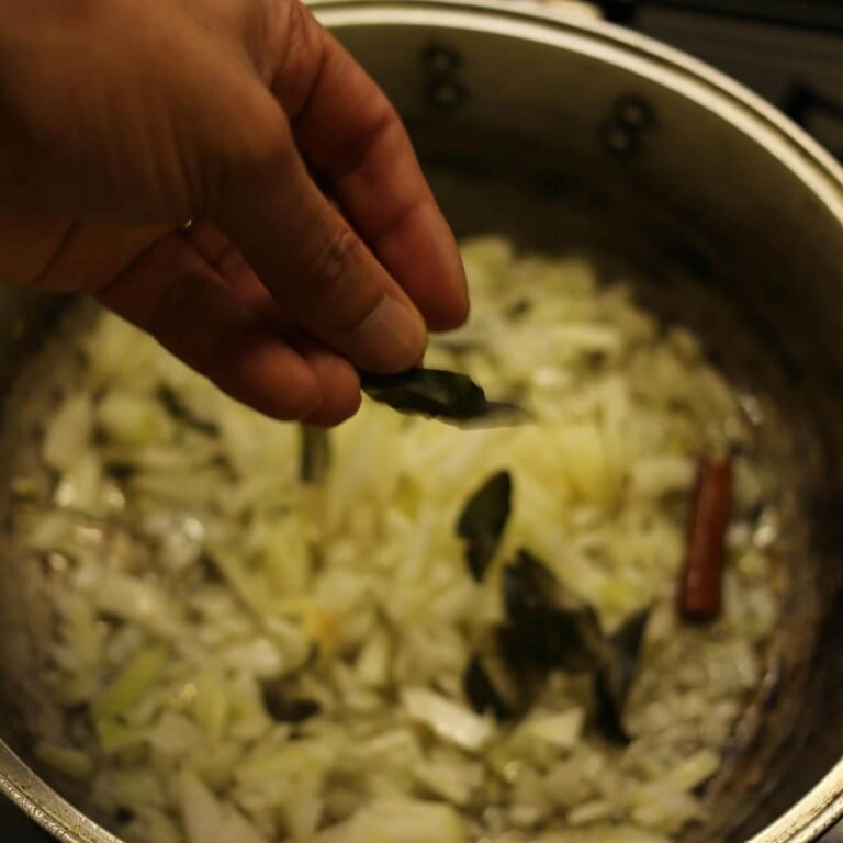 手順 3: カレーリーフと青唐辛子も加え、全体が薄い飴色になるまで炒める。