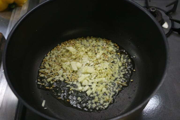手順 2: 香りが出てきたらにんにく・生姜を追加する。