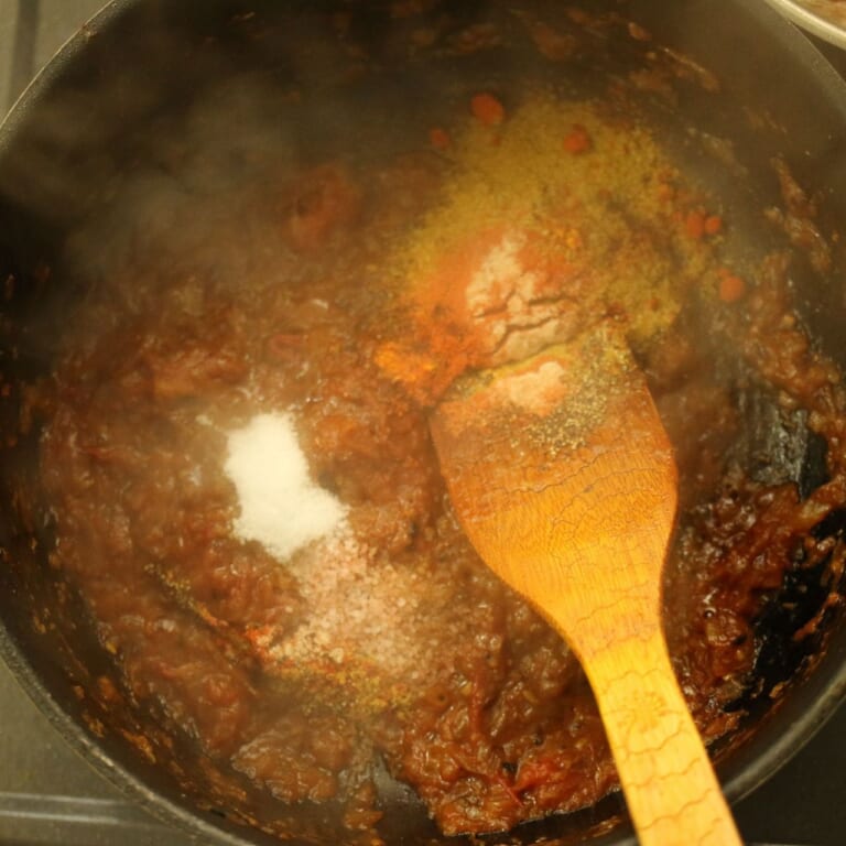 手順 4: トマトを加え水分がしっかりと飛ぶまで炒めてから、スパイスA、バジル、パセリ、パクチー、塩、砂糖を加え軽く炒める。