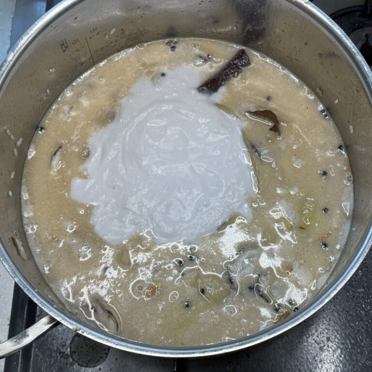 手順 5: 牡蠣を加え軽く混ぜ合わせたら水とココナッツミルクを加える。