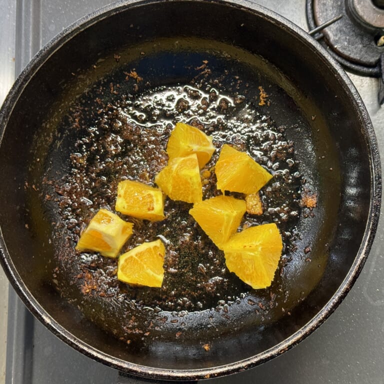 手順 3: もうひとつのオレンジは一口大に切り、表面をフライパンで焼きバットに入れておく。
