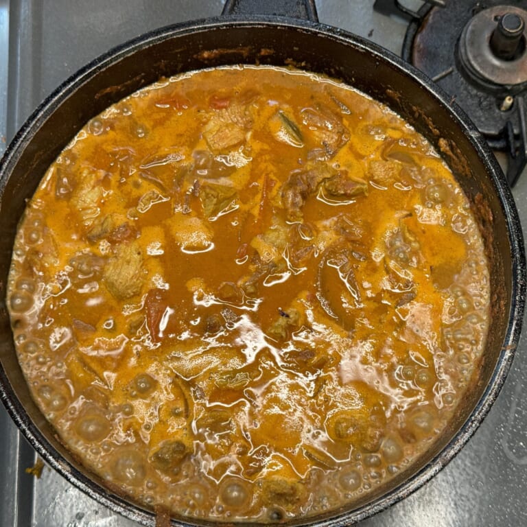 手順 6: 焼いておいた豚肉を戻し水で少しずつ伸ばしグツグツとしてきたらビネガーを加えて弱火で5分ほど煮込む。