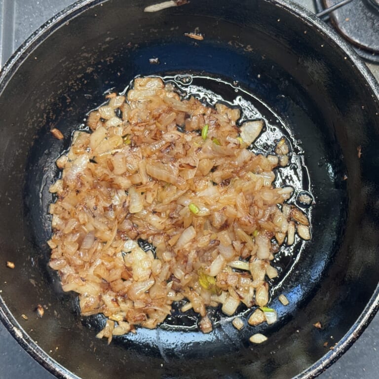 手順 2: 同じフライパンに油を熱し粗みじん切りした玉ねぎを飴色になるまで炒める。
