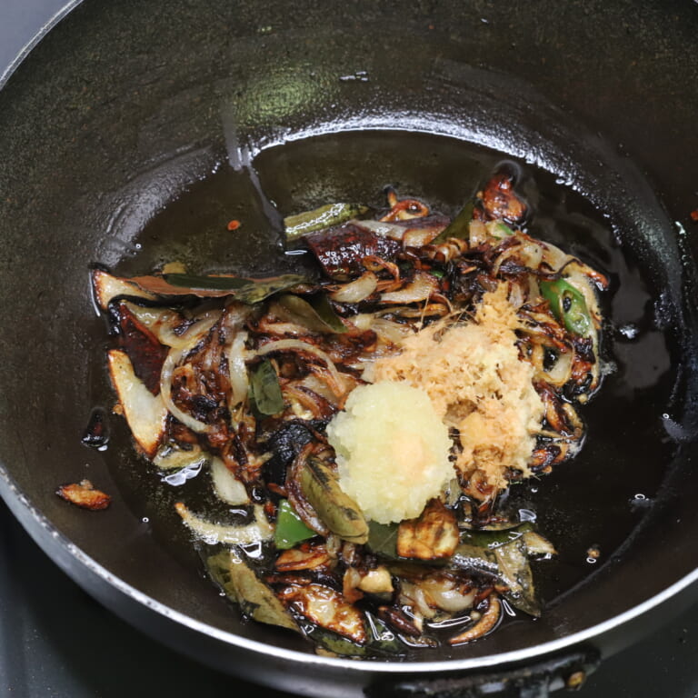 手順 3: 温めたフライパンに油とスパイスAを加え香りが立ったら玉ねぎを加える。透明になったら青唐辛子、カレーリーフを加え、飴色にな