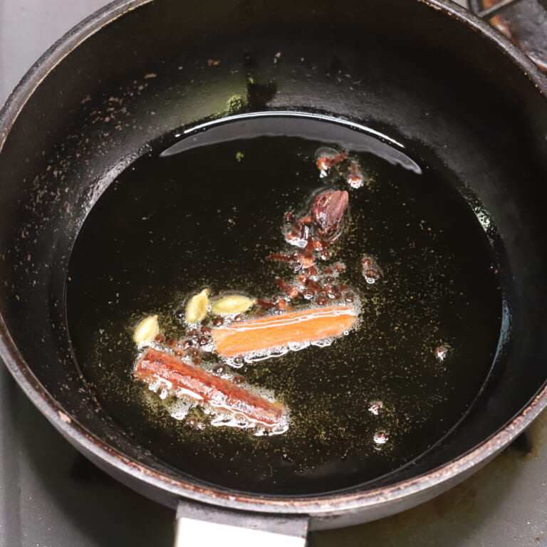手順 2: 温めたフライパンに揚げ油を大さじ3加えスパイスAを熱する。