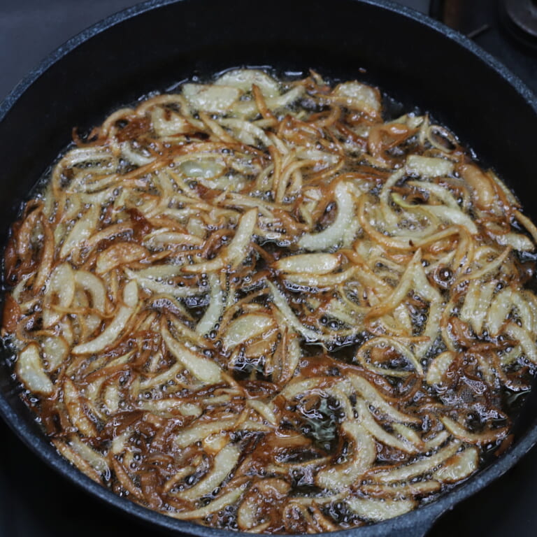 手順 1: スライスした玉ねぎを揚げ油でゴールデンブラウンになるまであげておく。