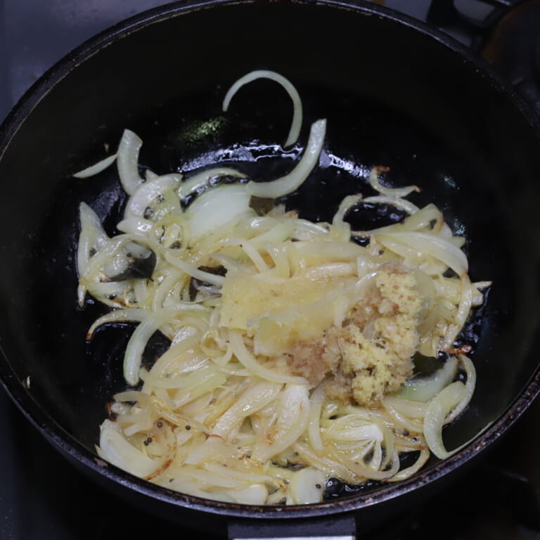 手順 3: パチパチと音がしてきたら玉ねぎを加え半透明になるまで炒めにんにく生姜を加える。