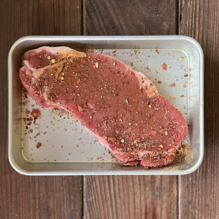 手順 1: 常温に戻し筋を切ったステーキ肉にスパイスミックスをまぶしておく。