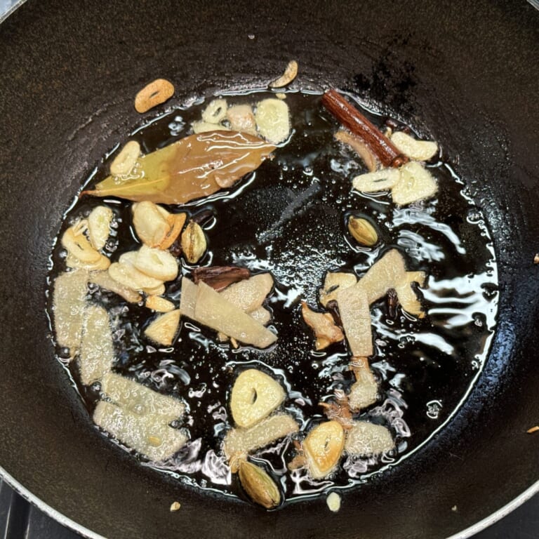 手順 3: 鍋に油とスパイスB、にんにくを加えほんのり色づくまで炒める。