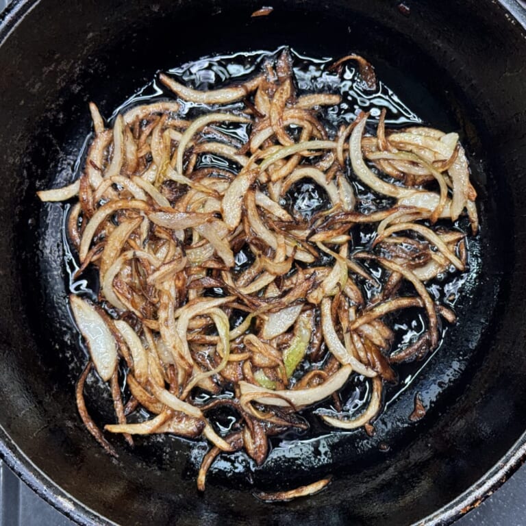 手順 5: 鍋にギーを加え熱し玉ねぎを炒め飴色になるまで炒める。その後、マリネしておいたラム肉をマリネ液ごと加えしっかりと炒めたらト