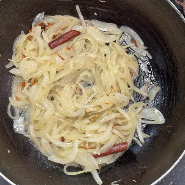 手順 3: 温めたフライパンにバターを熱し、ホールスパイスBを加え香りが立ってきたら玉ねぎを加え薄く透明になるまで炒める。（色がつき