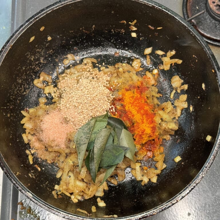 手順 4: カレーリーフ、スパイスC、塩（小さじ1）、白ゴマ大さじ1を入れ.炒める。