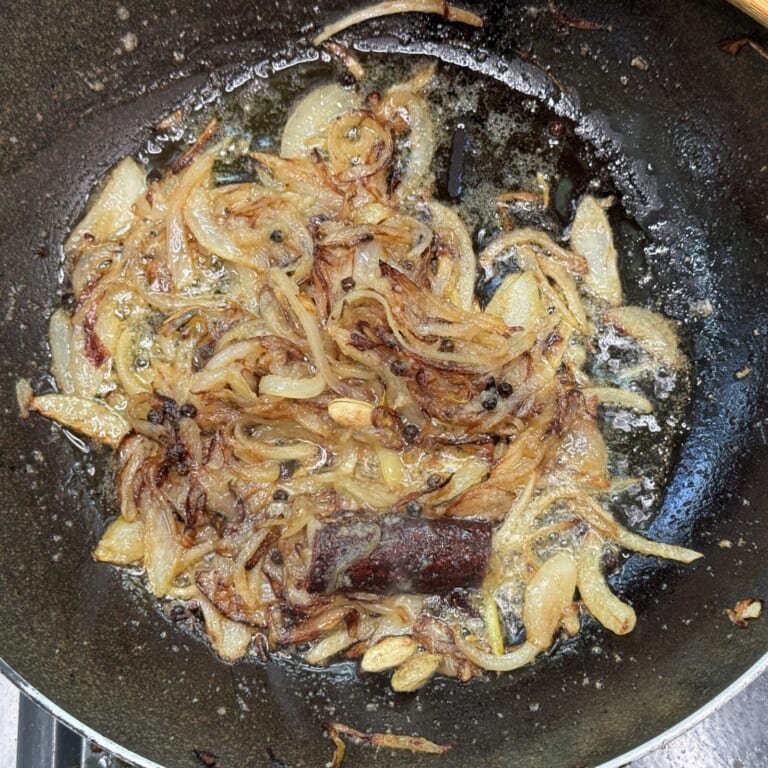 手順 4: 同じフライパンでスパイスAを熱する。 香りが立ってきたら玉ねぎを加え、飴色になったらおろしにんにく生姜を加え炒める。