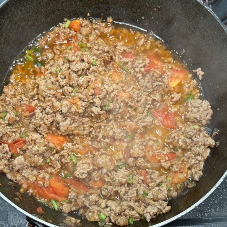 手順 5: 豚ひき肉を加えしっかりと火が入ったらトマトを加え油が分離するくらいまで炒める。