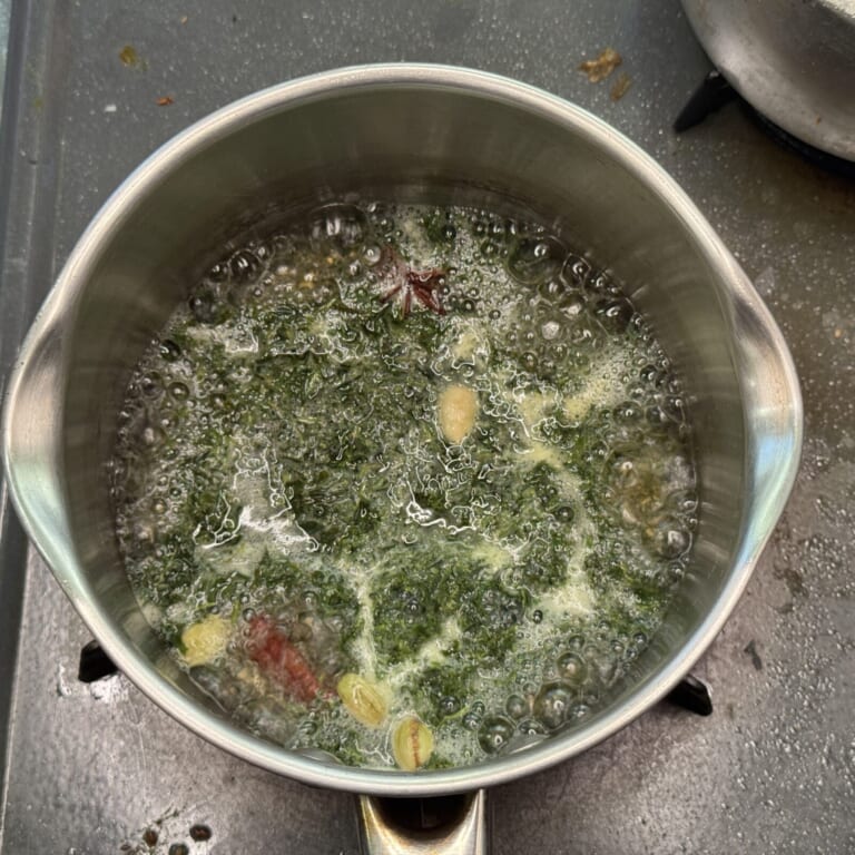 手順 2: 鍋に冷やしていない水（1）を入れスパイスAを加え火にかける軽くふつふつしてきたら緑茶を加え沸騰させる。