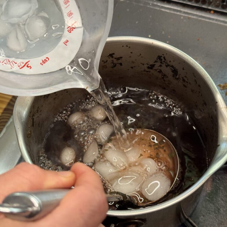 手順 4: 水分量が半分以下になったら用意しておいた氷水を加えさらに沸騰させ、よくかき混ぜる。