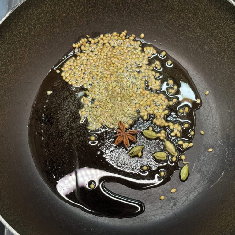 手順 2: 温めた鍋に油を加えスパイスAを加え香りが立ってきたら玉ねぎを炒める。