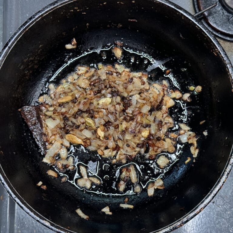 手順 3: 同じフライパンに油を加えスパイスAを熱し、香りが立ってきたら玉ねぎを飴色になるまで炒める。