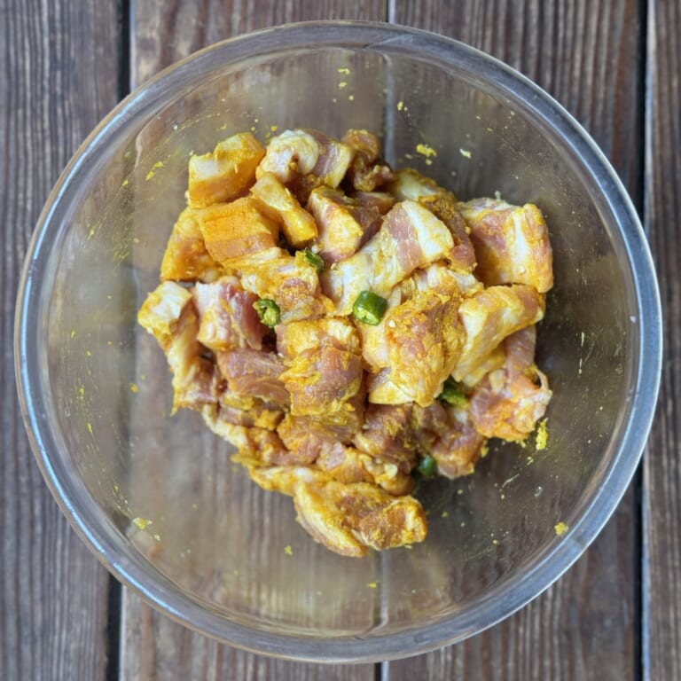手順 1: カットした豚肉をおろしニンニク、生姜、塩、スパイスA、青唐辛子でマリネしておく。
