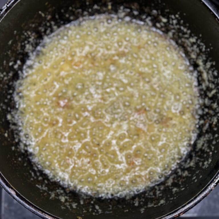 手順 3: 鶏もも肉を取り出しておき、油を加え熱しニンニク・生姜を加え火にかける。