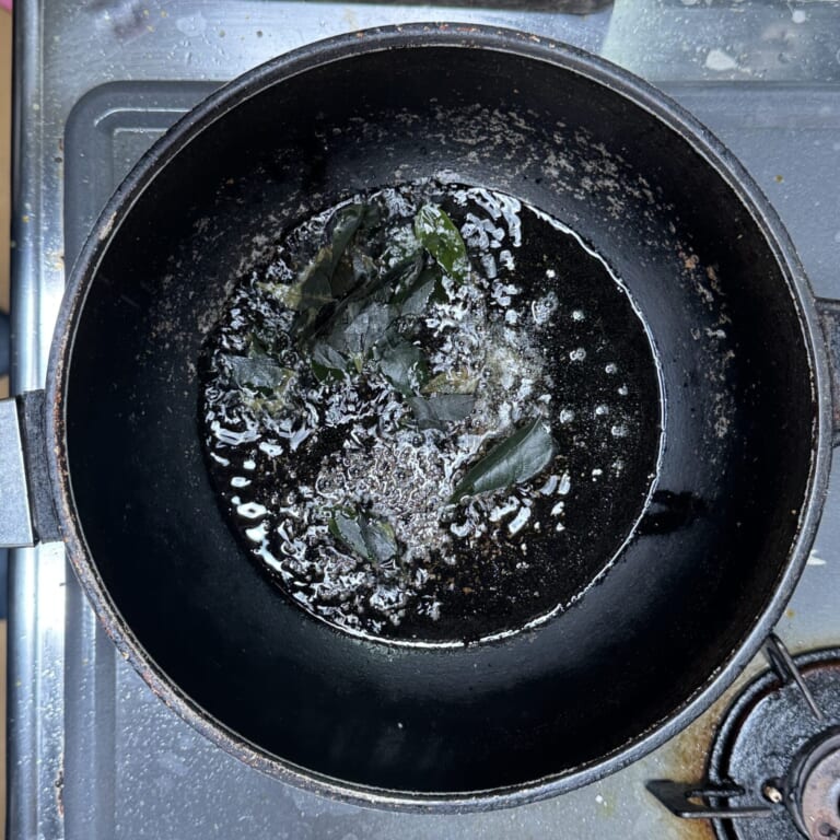 手順 2: 温めたフライパンに油を熱しマスタードシード、ヒング、カレーリーフの順に炒める。