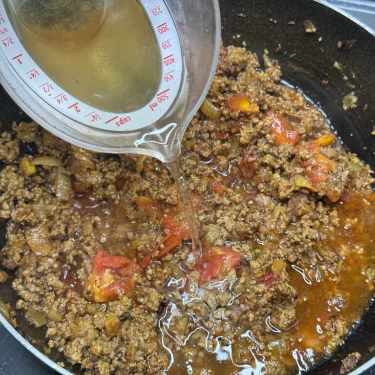 手順 5: 表面に油が浮いてきたらサンバルパウダー、刻んだ出汁ガラを加え炒め合わせかつおダシで伸ばしてグツグツとしてきたら弱火にして